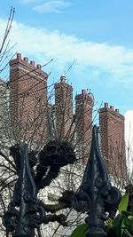 Statue of bare tree against sky