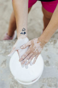 Woman putting chalk in her hands before practicing crossfit.