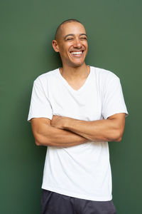 Portrait of young man standing against wall