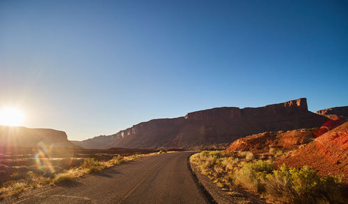 Road by mountains against clear sky