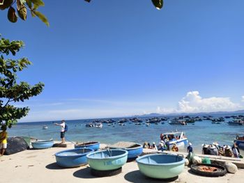 Boats on beach against blue sky