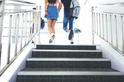 Low angle view of couple climbing stairs at airport