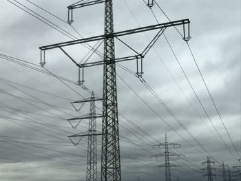 Low angle view of electricity pylon against sky