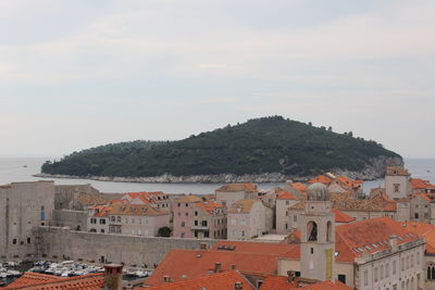 High angle view of town by sea against sky