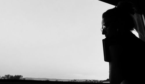 Rear view of silhouette man and woman against clear sky