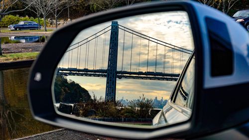 Reflection of trees on side-view mirror of car
