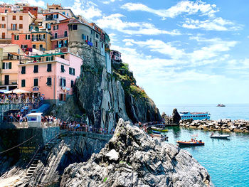 Buildings by sea against sky