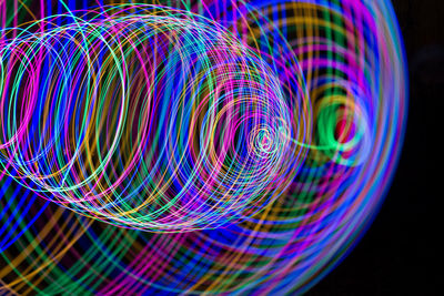 Multi colored light trails against black background