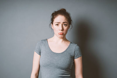 Portrait of beautiful young woman against wall