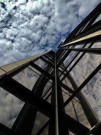 Low angle view of skyscraper against cloudy sky