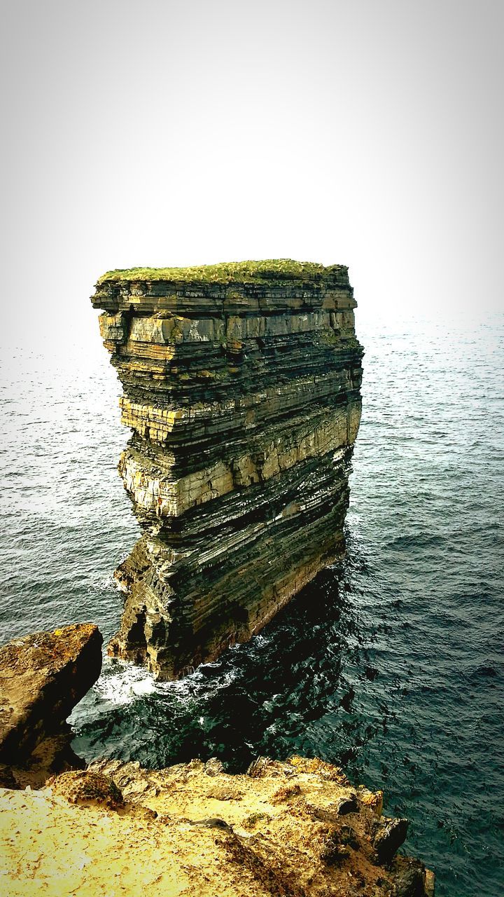 water, sea, clear sky, tranquility, nature, tranquil scene, rock - object, waterfront, scenics, copy space, reflection, lake, beauty in nature, outdoors, day, rippled, built structure, sky, abandoned, stone - object