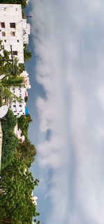 Buildings in city against cloudy sky