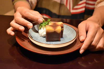 Close-up of man holding ice cream on table