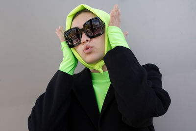 Portrait of woman wearing sunglasses against white background