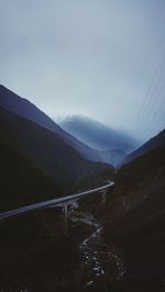 Bridge over mountain against sky