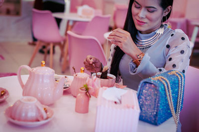 Midsection of woman with ice cream on table