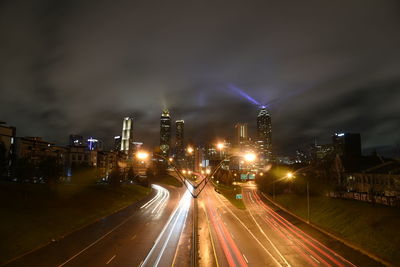 Light trails on road against sky at night