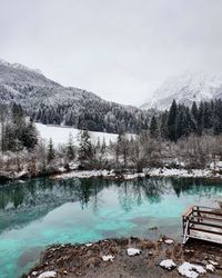 View of snowcapped mountains and green lake.