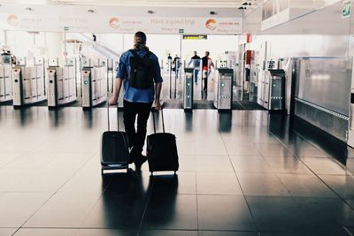 Rear view of men walking in airport