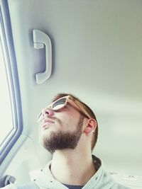 Low angle view of man wearing sunglasses while looking through window in car