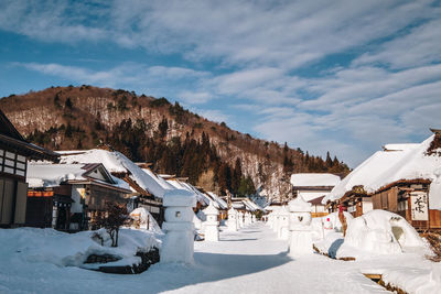 Panoramic view of buildings and snowcapped mountain against sky