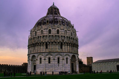 Low angle view of piazza dei miracoli against cloudy sky during dusk