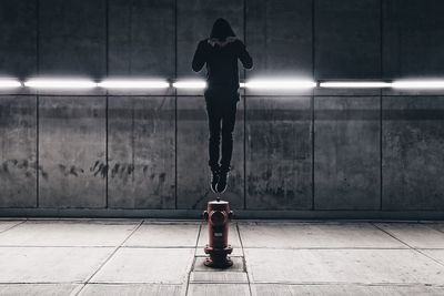 Man with umbrella in illuminated city at night