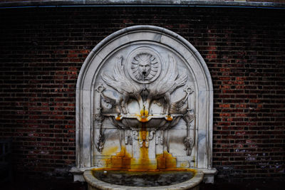 View of statue against brick wall