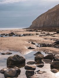 Rocks on beach against sky