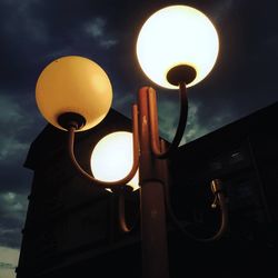Low angle view of illuminated street light against sky