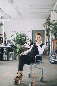 Young woman sitting on chair in room