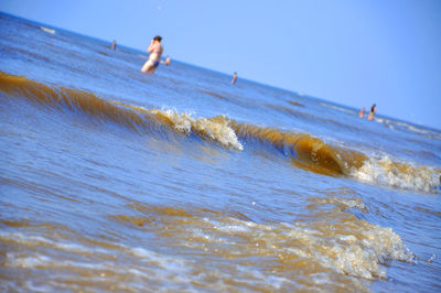 People at beach against sky