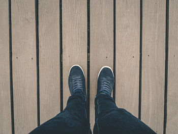 Low section of man standing on boardwalk