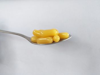 High angle view of yellow candies against white background