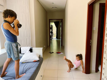 Boy taking photos of his little sister