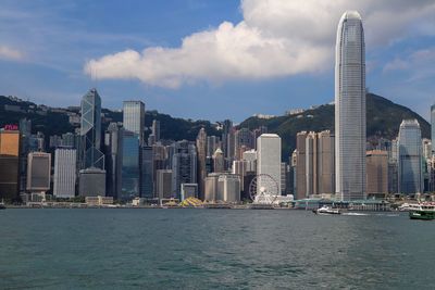 View of city buildings against cloudy sky