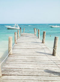 Wooden pier on sea against clear sky