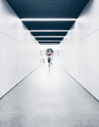 People walking in illuminated tunnel