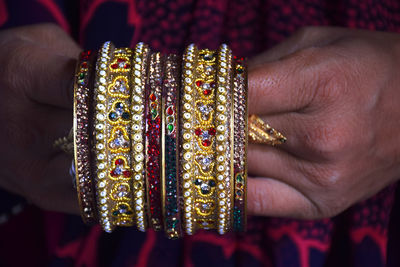 Midsection of woman holding bangles