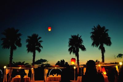 Silhouette palm trees against romantic sky at sunset