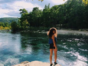 Full length of woman standing by river