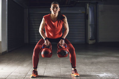 Full length portrait of senior woman with arms raised on floor