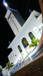 Low angle view of illuminated mosque against sky at night