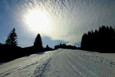 Snow covered road against sky during winter