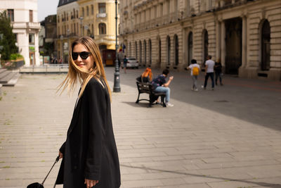 Beautiful young woman walking in the city of bucharest old town