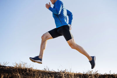 Full length of woman exercising against clear sky