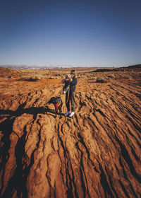 Side view of people skiing on desert against sky