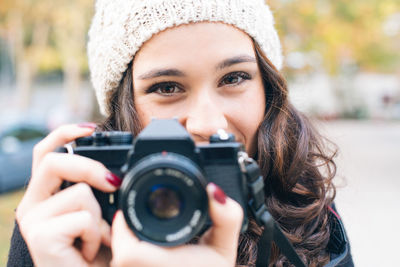 Portrait of woman holding camera