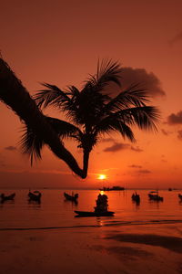 Silhouette palm tree at beach against sky during sunset