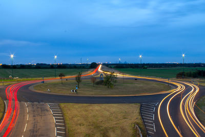 Light trails on road against sky at night